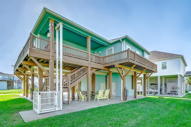 rear view of house featuring a lawn, a wooden deck, and a patio area