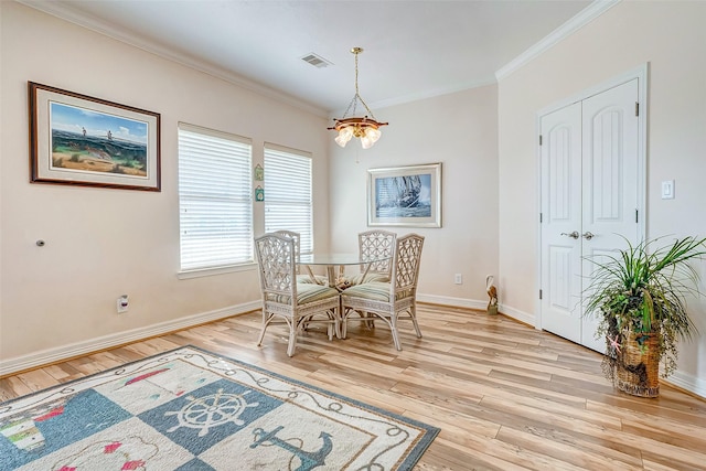 dining room featuring visible vents, light wood finished floors, baseboards, ornamental molding, and a notable chandelier