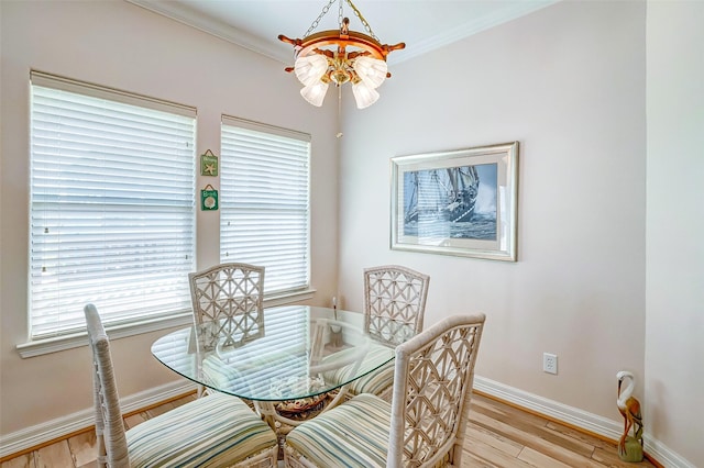dining space featuring baseboards, light wood-style floors, and ornamental molding