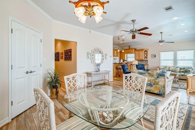 dining space featuring crown molding, light hardwood / wood-style floors, and ceiling fan