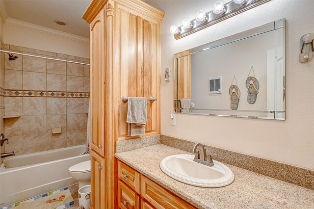 full bathroom featuring crown molding, vanity, toilet, and tiled shower / bath