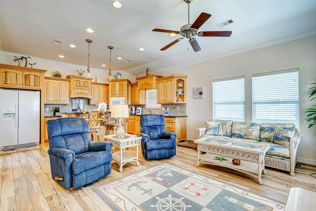 living room featuring light hardwood / wood-style flooring, ceiling fan, and ornamental molding