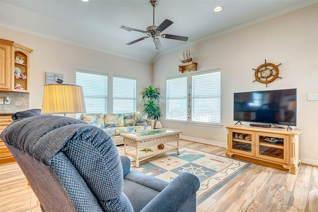 living area with ornamental molding, baseboards, light wood-style floors, and ceiling fan