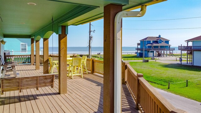 wooden deck with a water view and a yard