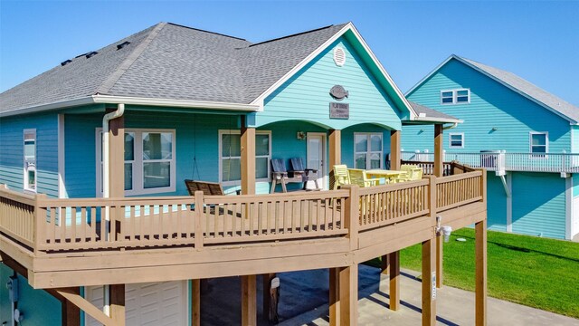 rear view of property featuring a garage and a deck