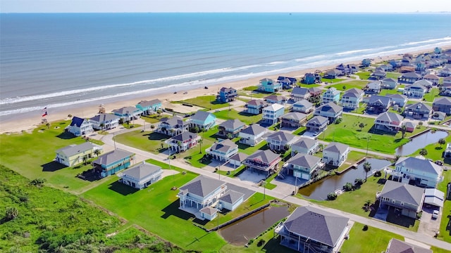 bird's eye view featuring a view of the beach, a residential view, and a water view