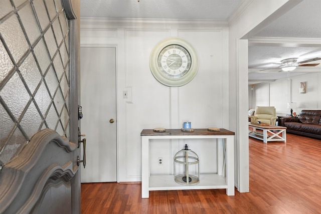 foyer entrance with ornamental molding, a textured ceiling, ceiling fan, and dark hardwood / wood-style flooring