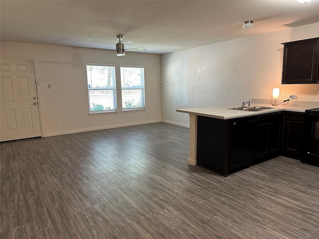 kitchen with ceiling fan, sink, dark hardwood / wood-style floors, kitchen peninsula, and stove