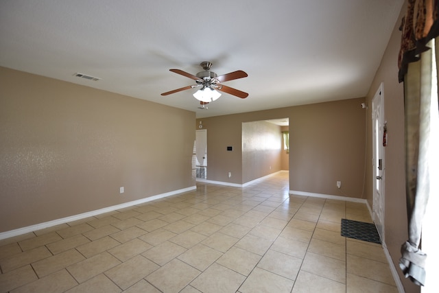 tiled empty room featuring ceiling fan