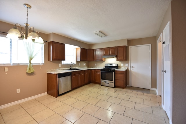 kitchen with light tile patterned flooring, hanging light fixtures, sink, appliances with stainless steel finishes, and an inviting chandelier