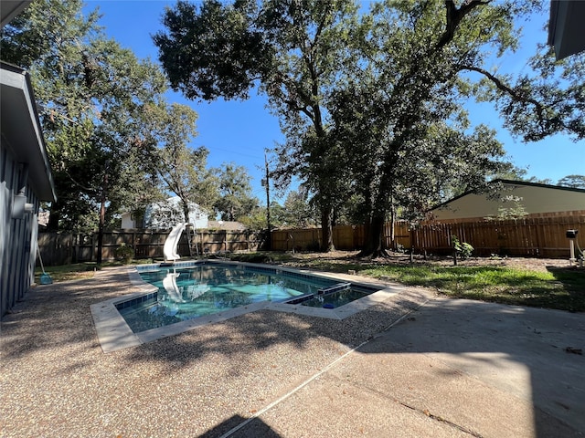 view of swimming pool with a patio area, an in ground hot tub, and a water slide