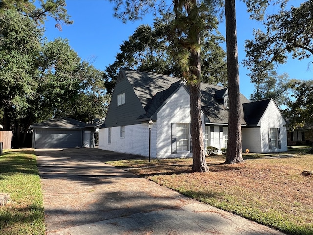 view of side of property with a yard, an outdoor structure, and a garage