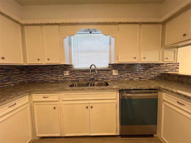 kitchen with white cabinets, decorative backsplash, stainless steel dishwasher, and sink