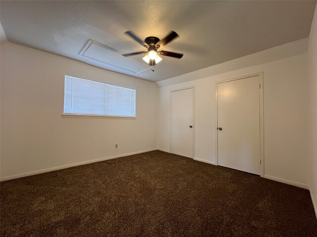 unfurnished bedroom with dark colored carpet and ceiling fan