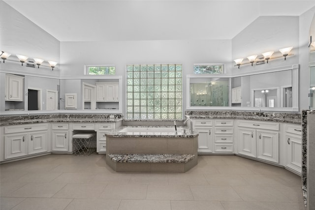 bathroom featuring tile patterned flooring, vanity, and a washtub