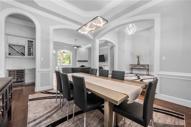 dining space with ceiling fan with notable chandelier, ornamental molding, dark hardwood / wood-style floors, and beverage cooler