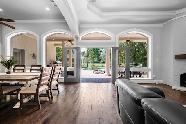 dining room with crown molding, a fireplace, dark hardwood / wood-style floors, and ceiling fan