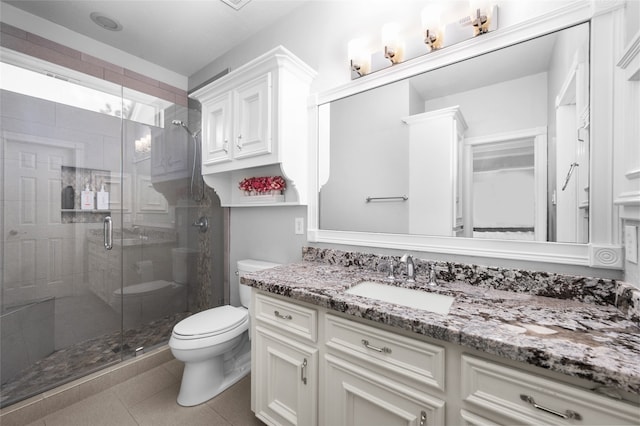 bathroom with vanity, toilet, tile patterned floors, and a shower with shower door