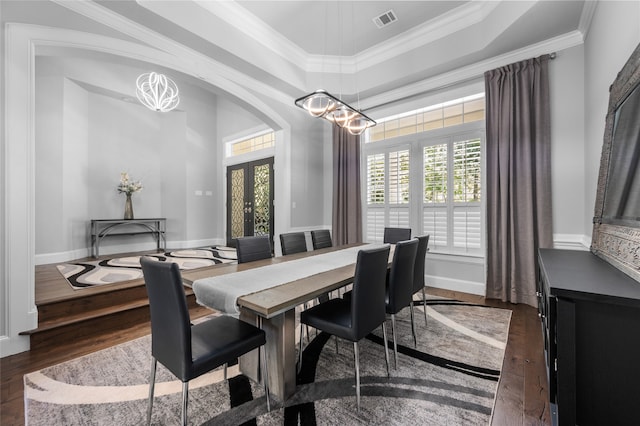 dining area featuring an inviting chandelier, crown molding, dark hardwood / wood-style flooring, and french doors