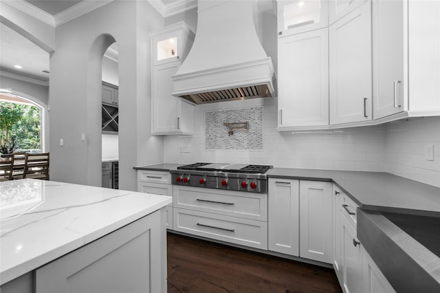 kitchen with custom exhaust hood, stainless steel gas cooktop, and white cabinetry