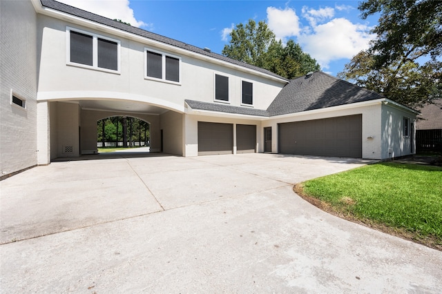 view of front of house with a carport, a garage, and a front yard