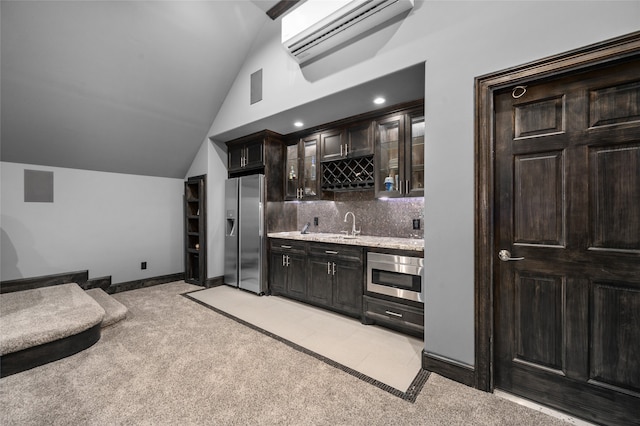 bar featuring lofted ceiling, dark brown cabinets, light colored carpet, and appliances with stainless steel finishes