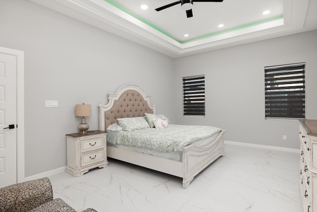 bedroom with a raised ceiling and ceiling fan