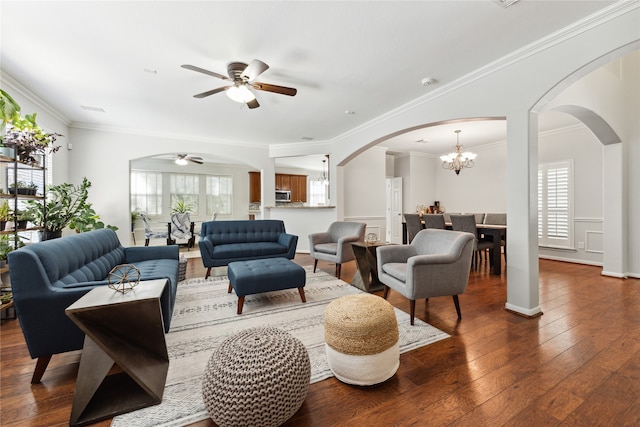 living room with ceiling fan with notable chandelier, ornamental molding, and hardwood / wood-style floors