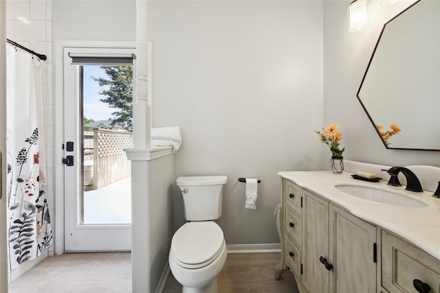 bathroom with tile patterned flooring, vanity, and toilet