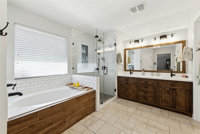 bathroom with tile patterned flooring, vanity, and plus walk in shower