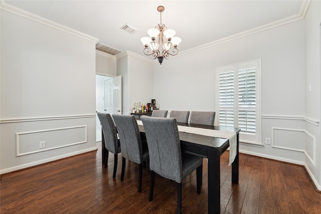 dining room with an inviting chandelier, ornamental molding, and dark hardwood / wood-style flooring