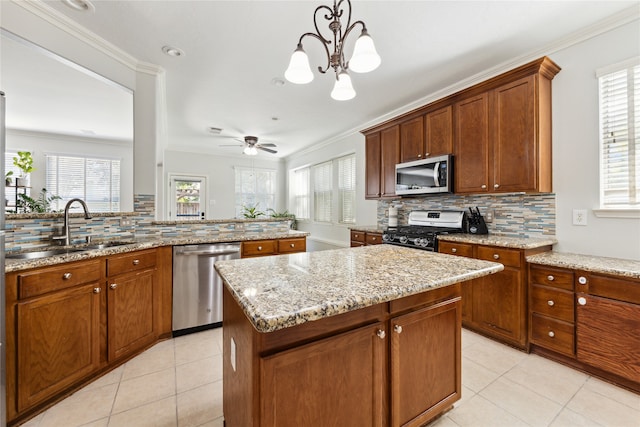 kitchen featuring ceiling fan with notable chandelier, appliances with stainless steel finishes, plenty of natural light, and pendant lighting