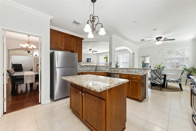 kitchen featuring ceiling fan with notable chandelier, kitchen peninsula, appliances with stainless steel finishes, and ornamental molding