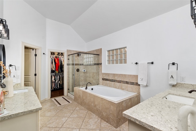 bathroom with vanity, shower with separate bathtub, tile patterned flooring, and vaulted ceiling