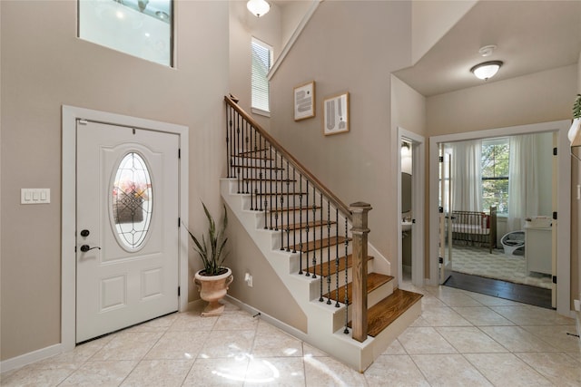 tiled entryway featuring a high ceiling