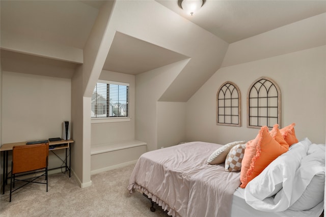 bedroom with light colored carpet and lofted ceiling