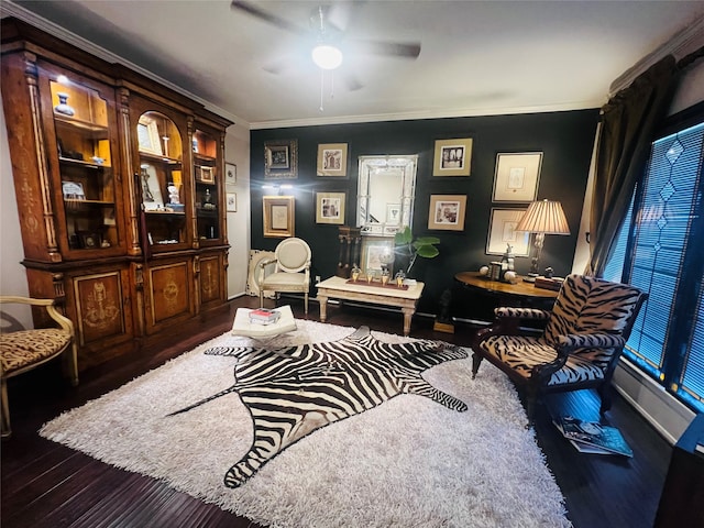 living area featuring wood-type flooring, ornamental molding, and ceiling fan