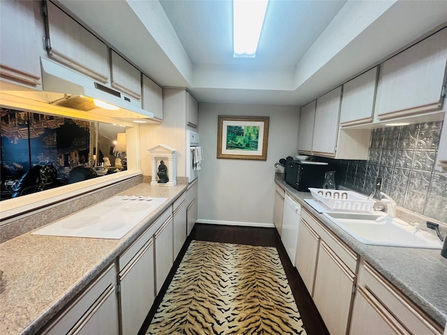 kitchen with dark hardwood / wood-style floors, tasteful backsplash, sink, white cabinets, and white appliances