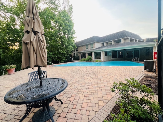 view of pool featuring central AC unit and a patio