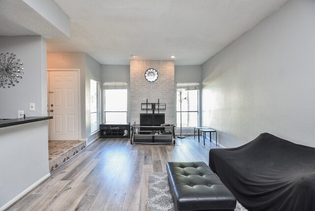 living room with hardwood / wood-style floors, a healthy amount of sunlight, and a textured ceiling