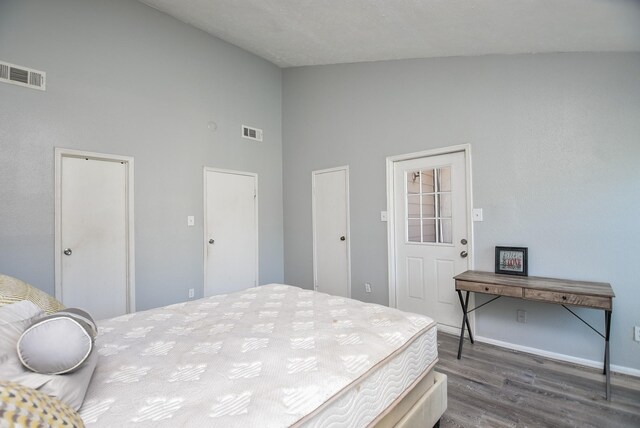 bedroom featuring dark hardwood / wood-style flooring and high vaulted ceiling