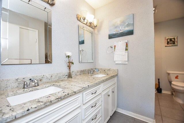 bathroom featuring tile patterned flooring, vanity, and toilet