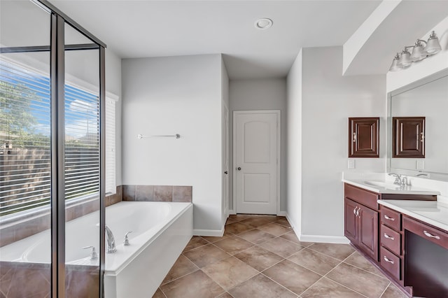 bathroom featuring tile patterned floors, a bath, and vanity