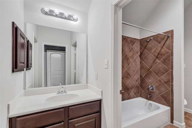 full bathroom with tiled shower / bath, vanity, and toilet