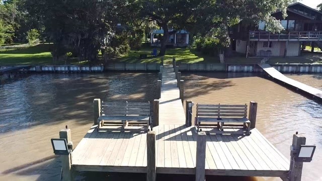 view of dock with a pool side deck with water view