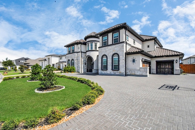 mediterranean / spanish-style home featuring a front yard and a garage