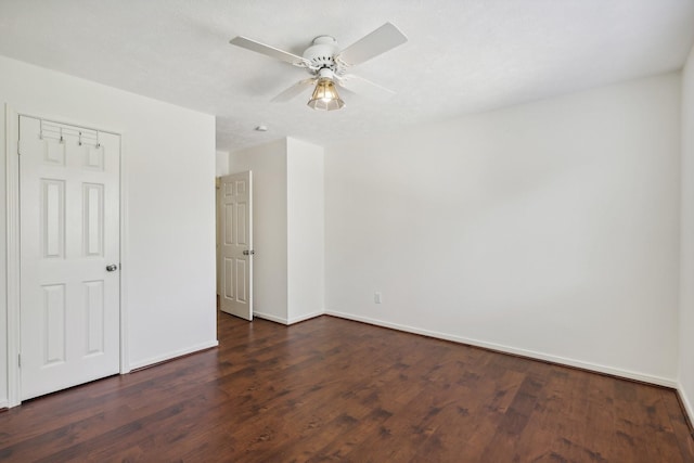 unfurnished room featuring ceiling fan and dark wood-type flooring