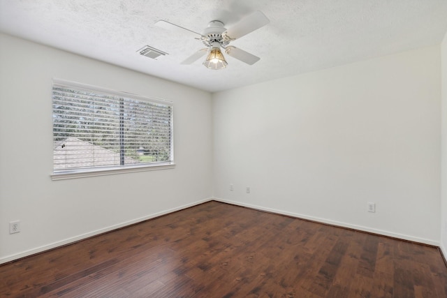 spare room with a textured ceiling, ceiling fan, and dark wood-type flooring