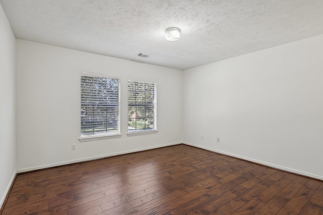 unfurnished room with a textured ceiling and dark hardwood / wood-style floors