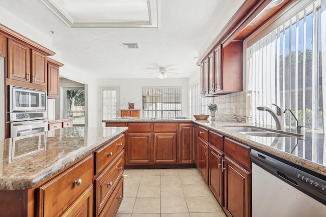 kitchen featuring tasteful backsplash, a healthy amount of sunlight, sink, and stainless steel appliances